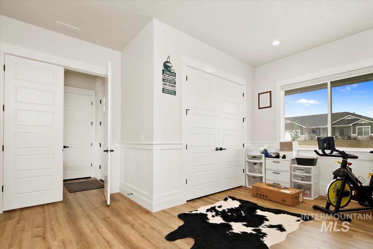 6721 El Paso Road Caldwell, ID 83607 - Photo 7 of 50 Exercise area featuring a wainscoted wall, light wood-type flooring, and a decorative wall