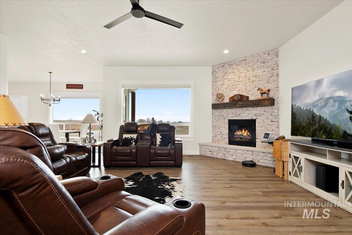 6721 El Paso Road Caldwell, ID 83607 - Photo 8 of 50 Living area with light wood finished floors, plenty of natural light, a fireplace, a chandelier, and recessed lighting