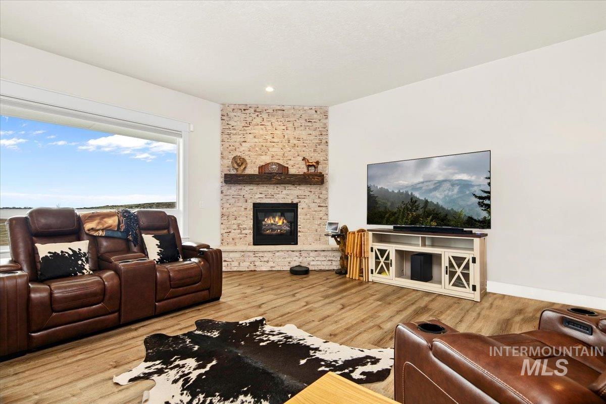 6721 El Paso Road Caldwell, ID 83607 - Photo 10 of 50 Living room with wood finished floors and a brick fireplace