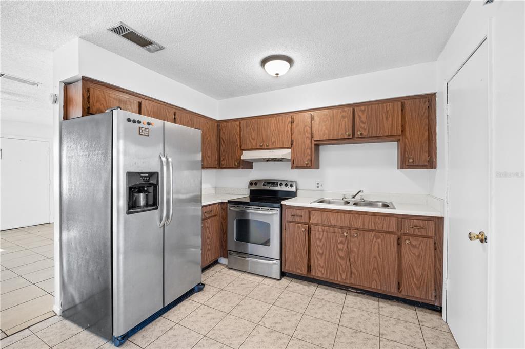 764 Lunar Lake Circle Cocoa, FL 32926 - Photo 2 of 17 a kitchen with stainless steel appliances granite countertop a refrigerator sink and cabinets