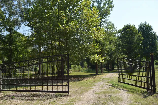 a view of backyard with wooden fence and trees