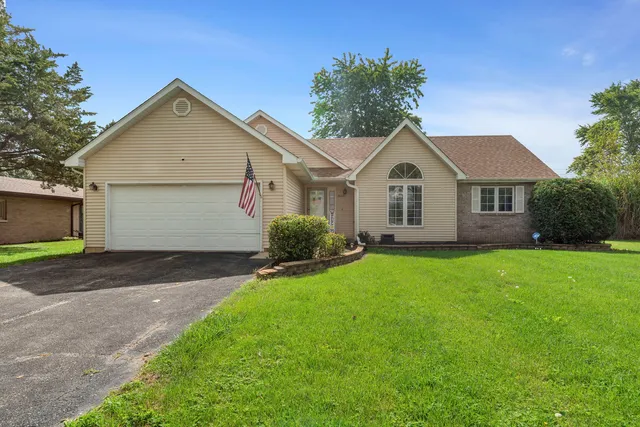 a front view of a house with a garden and yard