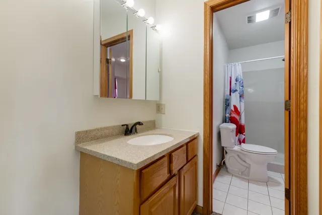 a bathroom with a sink vanity mirror and toilet