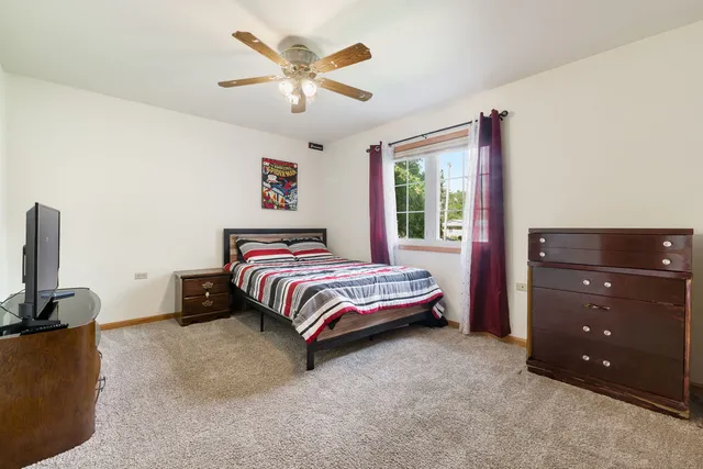 a bedroom with a bed and a tv on the dresser