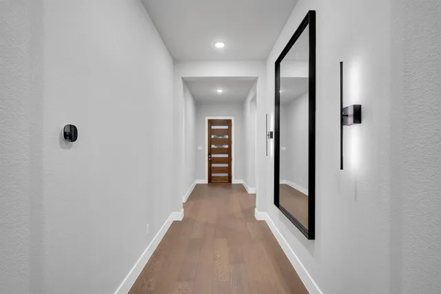 a view of a hallway with wooden floor and staircase