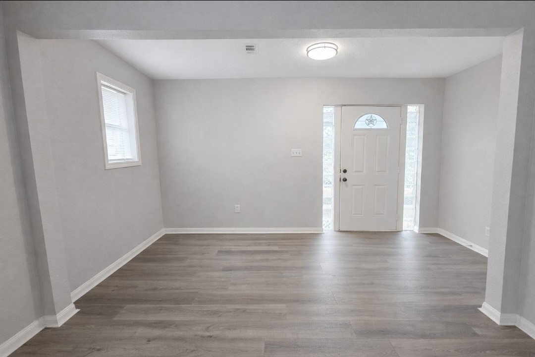 309 E Pine Daisetta, TX 77533 - Photo 16 of 23 a view of an empty room with wooden floor and a window