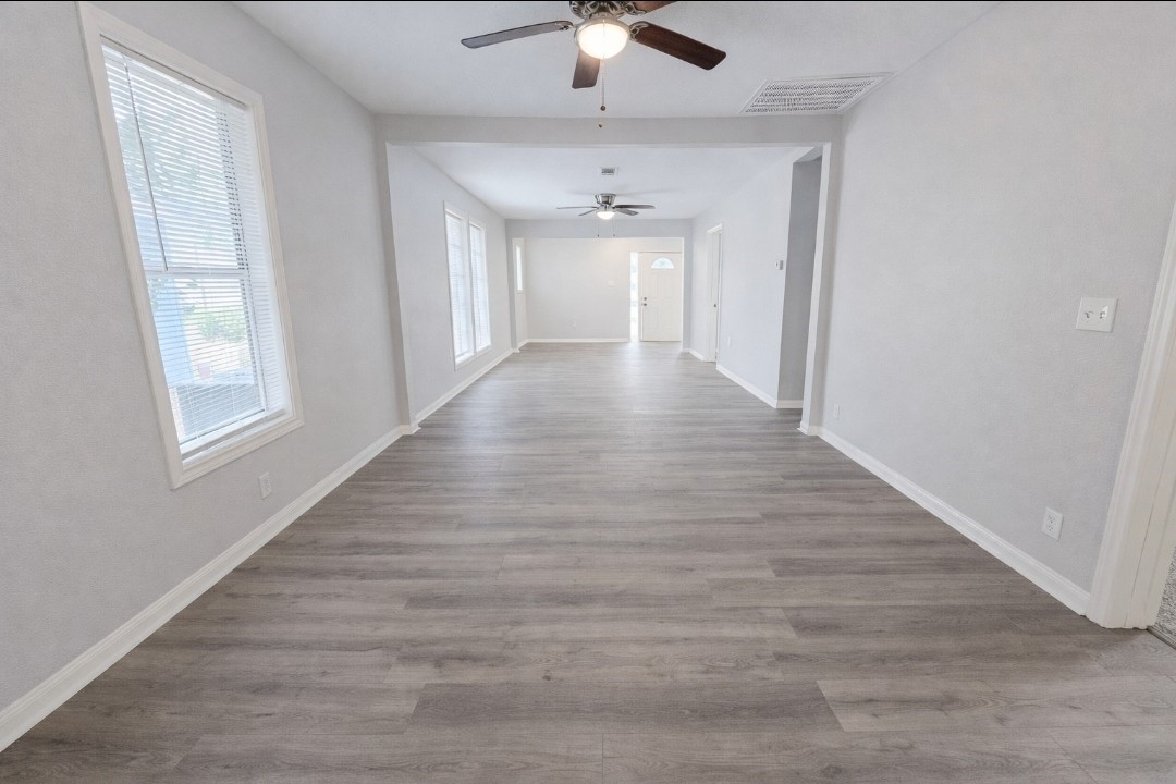 309 E Pine Daisetta, TX 77533 - Photo 4 of 23 wooden floor in an empty room with a window