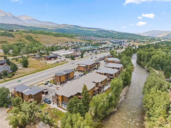 an aerial view of a city with lots of residential buildings and mountain view in back