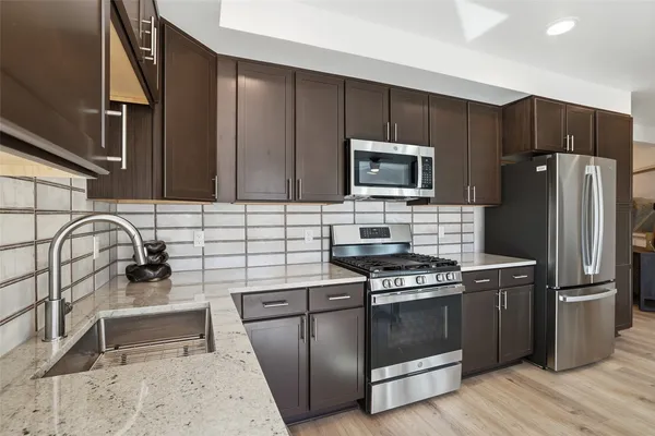 a kitchen with granite countertop a stove and a refrigerator
