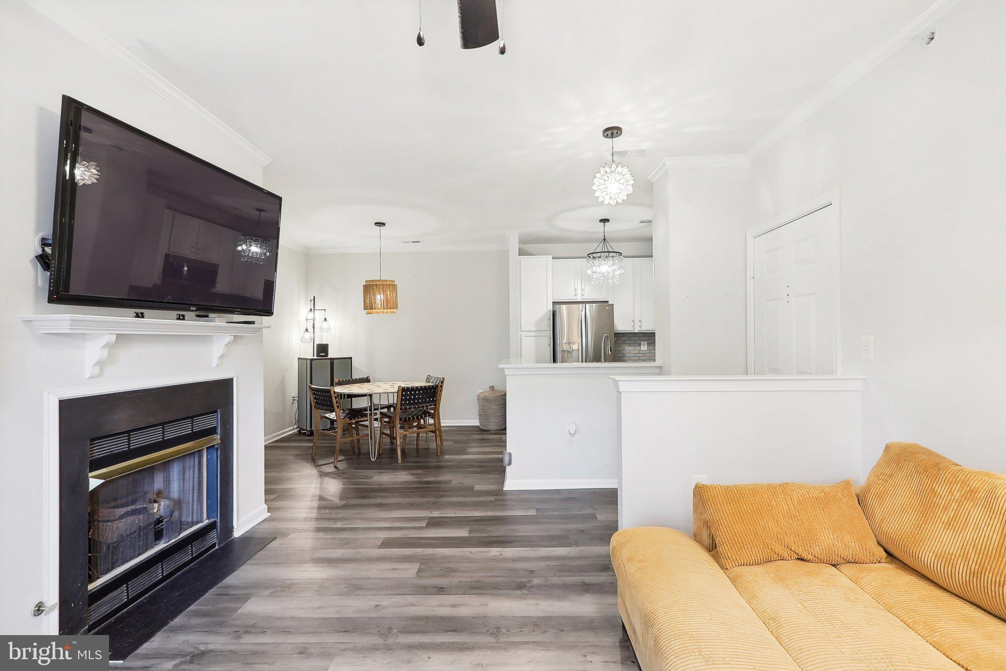1516 North Point Drive, Unit 301 Reston, VA 20194 - Photo 11 of 31 a living room with furniture a fireplace and a flat screen tv