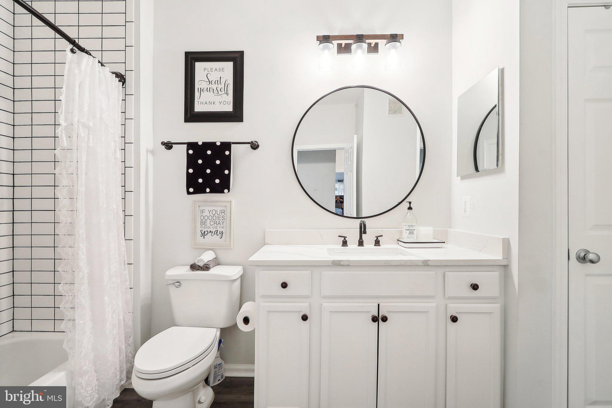 1516 North Point Drive, Unit 301 Reston, VA 20194 - Photo 16 of 31 a bathroom with a toilet a sink and a mirror