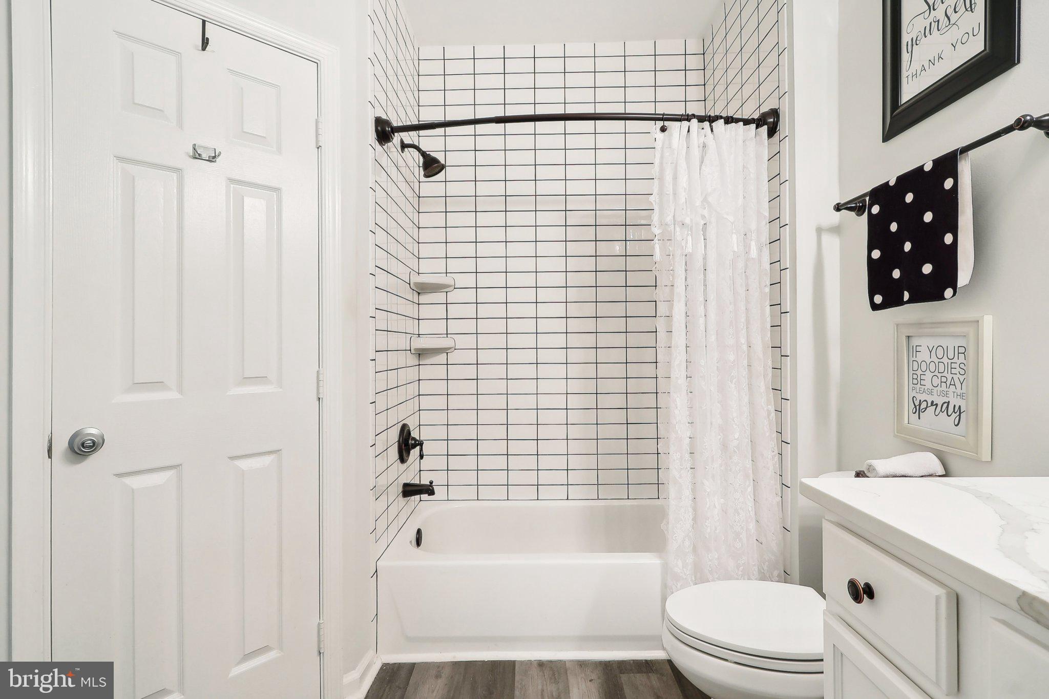 1516 North Point Drive, Unit 301 Reston, VA 20194 - Photo 20 of 31 a bathroom with a bathtub shower sink vanity and toilet