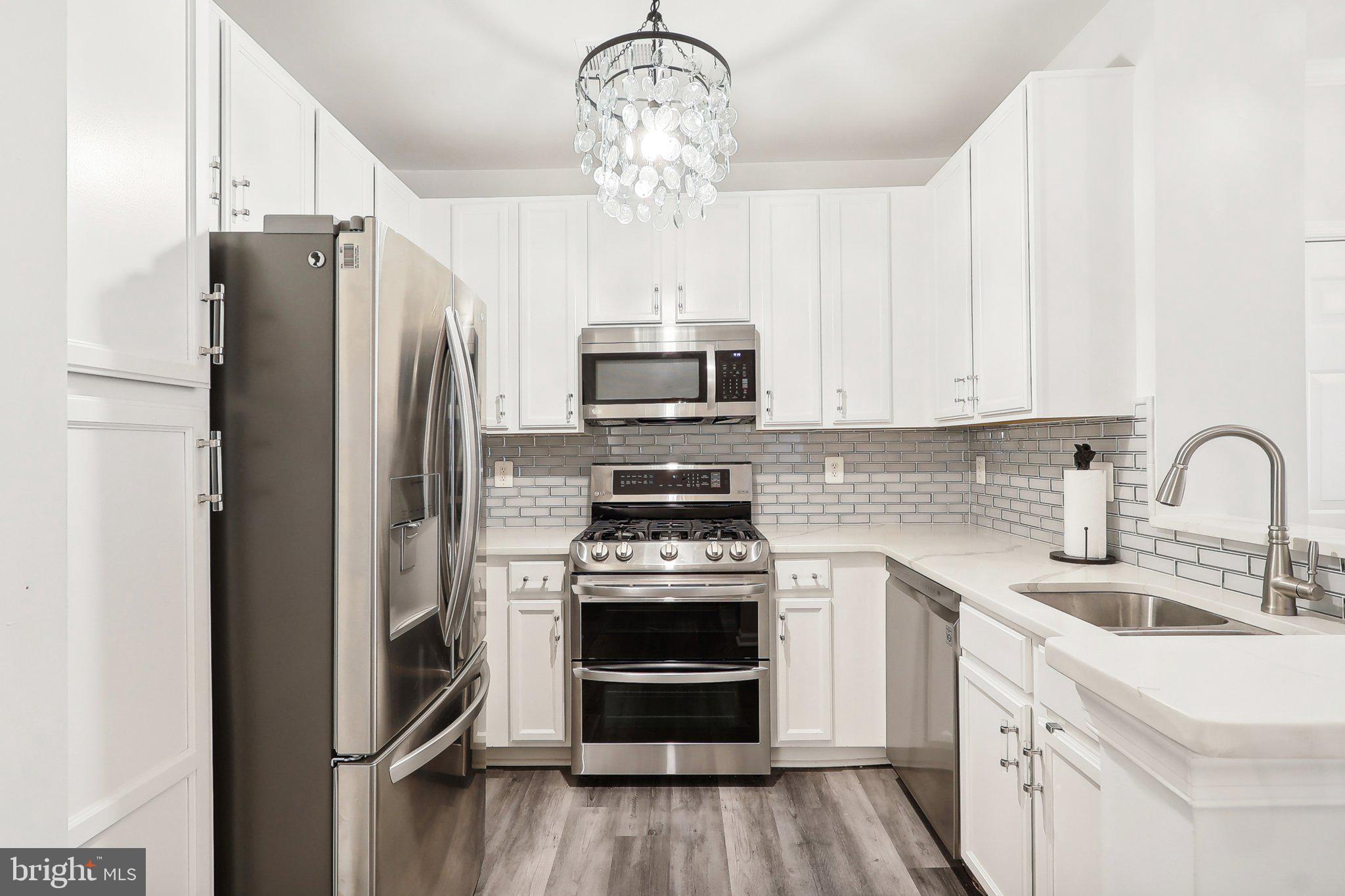 1516 North Point Drive, Unit 301 Reston, VA 20194 - Photo 5 of 31 a kitchen with a sink stainless steel appliances and cabinets