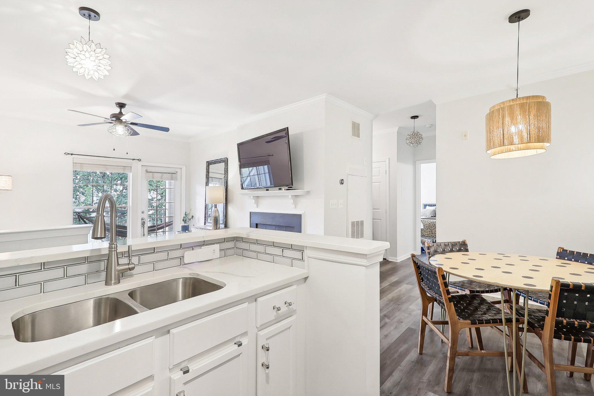 1516 North Point Drive, Unit 301 Reston, VA 20194 - Photo 7 of 31 a kitchen with granite countertop a sink a center island and cabinets