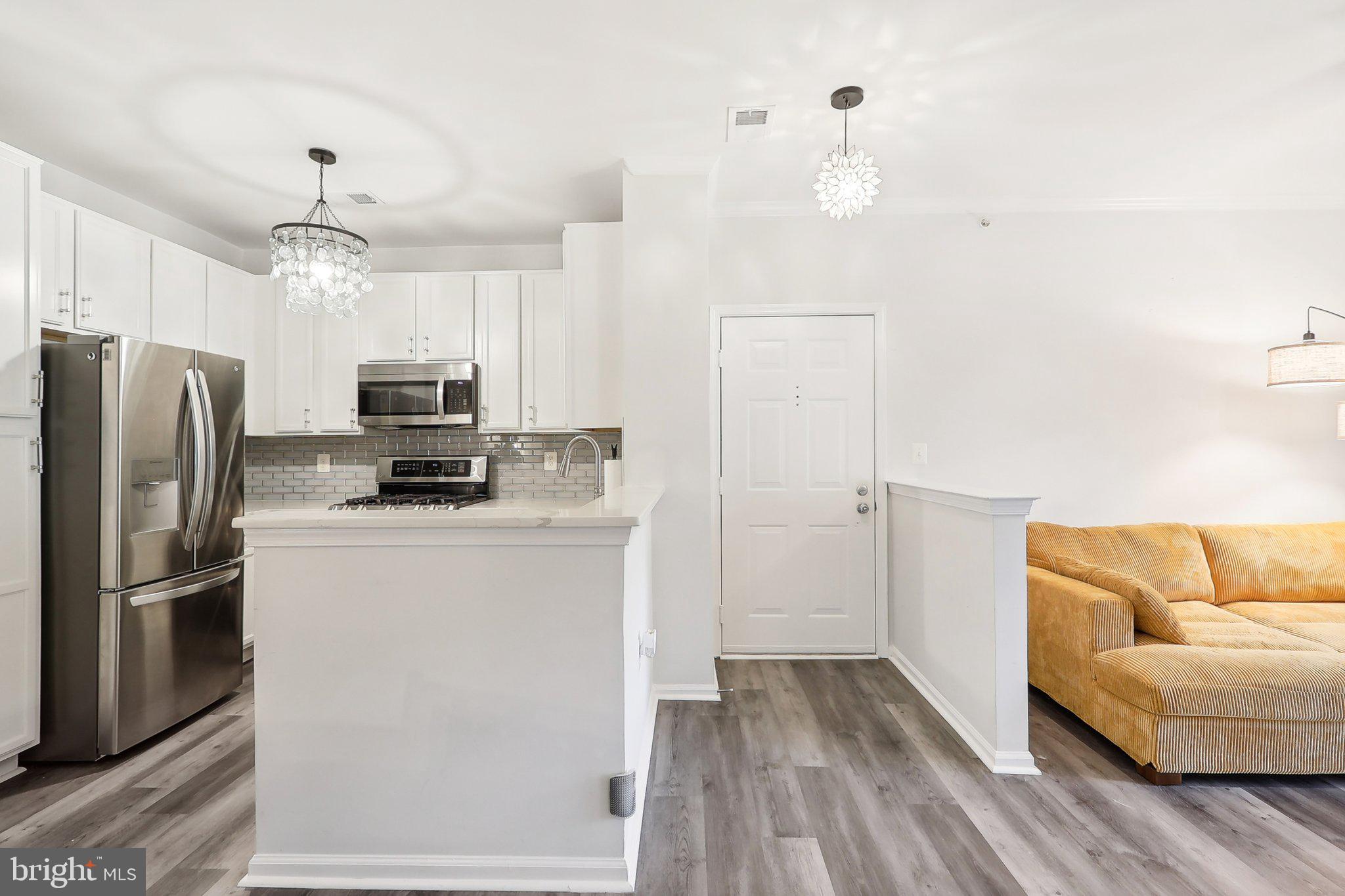 1516 North Point Drive, Unit 301 Reston, VA 20194 - Photo 10 of 31 a kitchen with stainless steel appliances a refrigerator sink and microwave