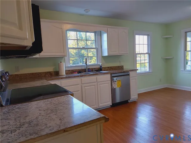 a kitchen with granite countertop a stove and wooden cabinets