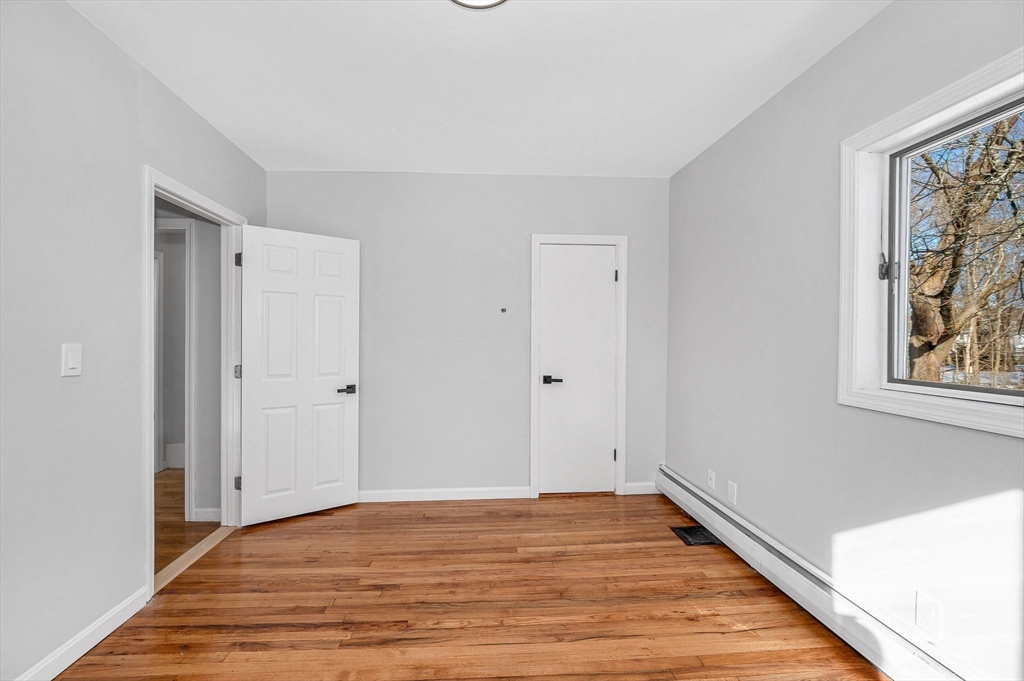 52 Elm Street Haverhill, MA 01830 - Photo 27 of 40 a view of an empty room with wooden floor and window