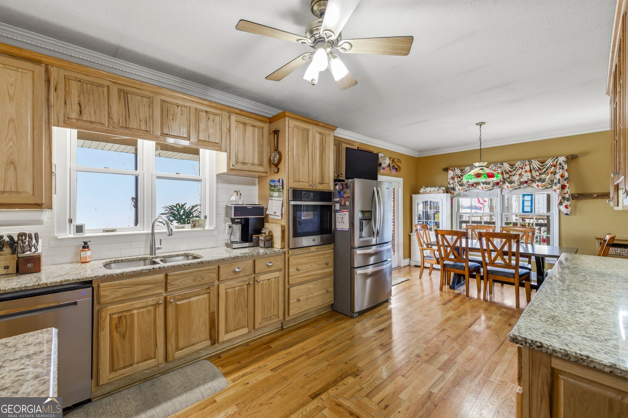 401 Herrin Road Cornelia, GA 30531 - Photo 12 of 83 a kitchen with stainless steel appliances granite countertop a refrigerator a sink dishwasher a dining table and chairs with wooden floor