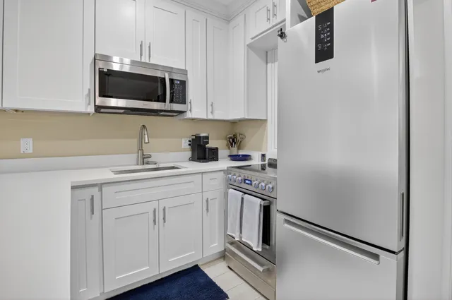 a kitchen with stainless steel appliances granite countertop white cabinets stove a sink and dishwasher