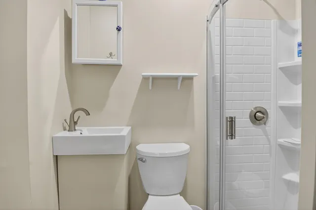 a bathroom with a sink a toilet and shower