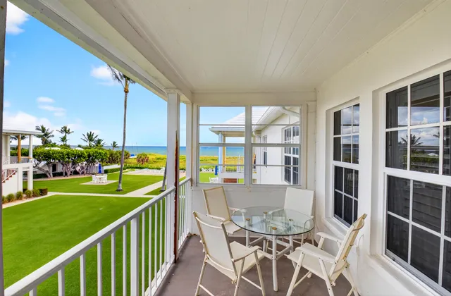 a view of a patio with table and chairs potted plants with floor to ceiling window