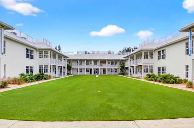 a view of a house with a big yard and potted plants