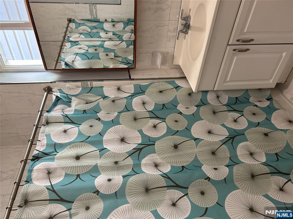 192 Kearny Avenue, Unit 2 Kearny, NJ 07032 - Photo 14 of 16 a bathroom with a sink mirror and vanity