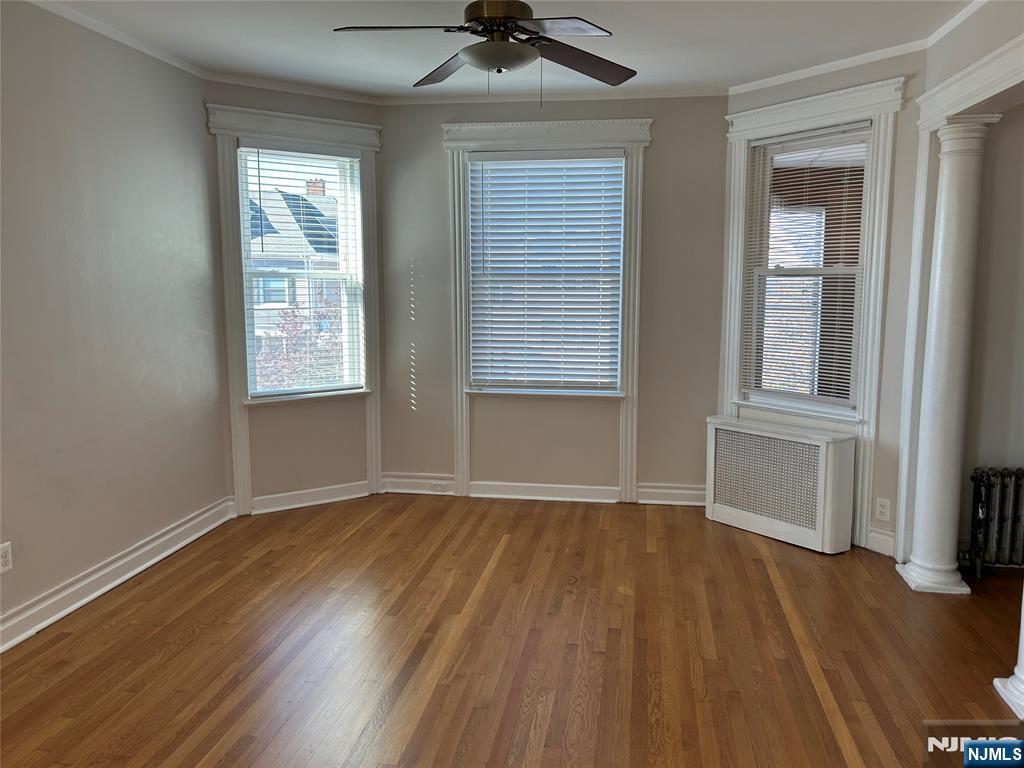 192 Kearny Avenue, Unit 2 Kearny, NJ 07032 - Photo 2 of 16 an empty room with wooden floor a ceiling fan and windows