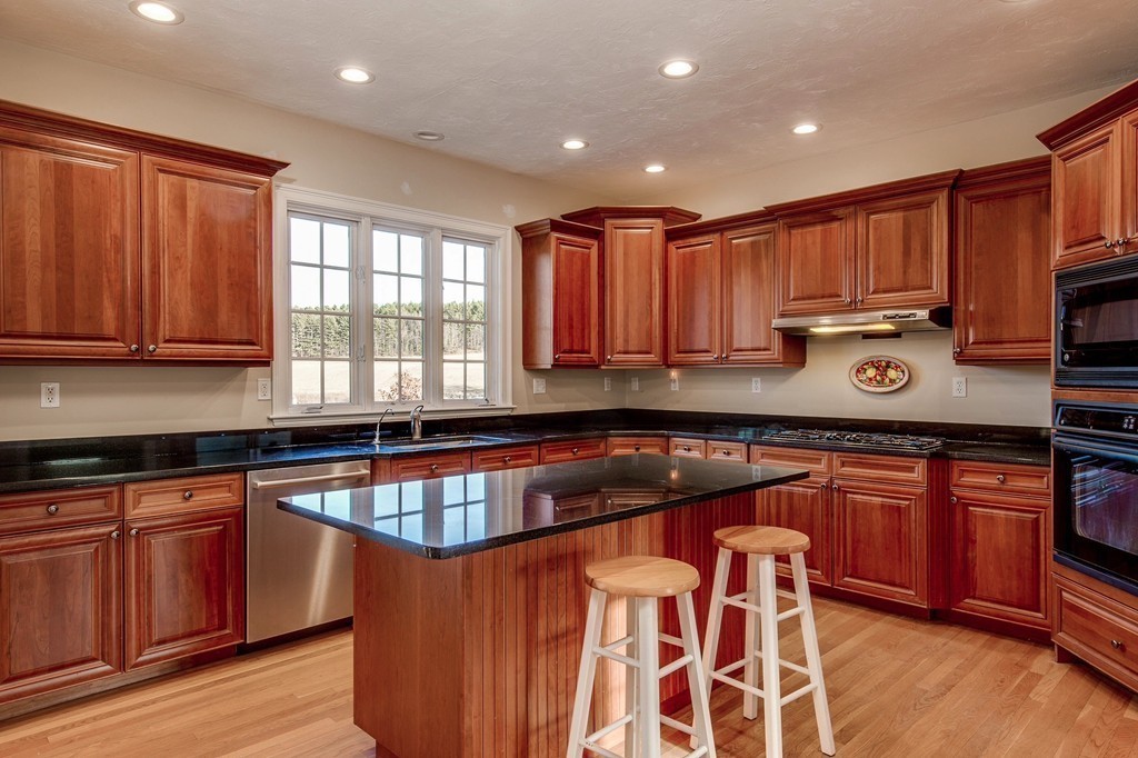 311 Still River Road Harvard, MA 01451 - Photo 4 of 27 a kitchen with stainless steel appliances granite countertop wooden cabinets a stove a sink and dishwasher with wooden floor