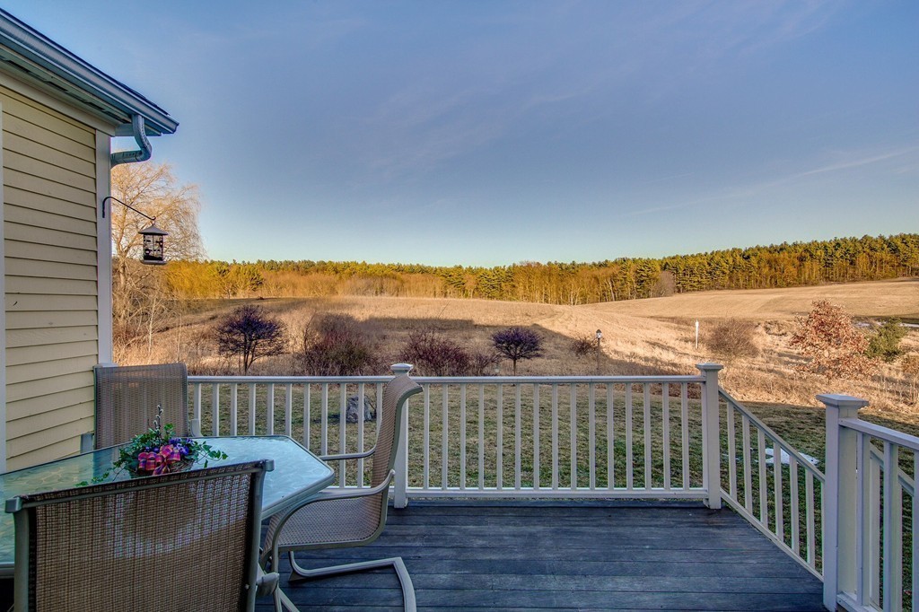 311 Still River Road Harvard, MA 01451 - Photo 9 of 27 a view of a balcony with wooden chairs and floor to ceiling window