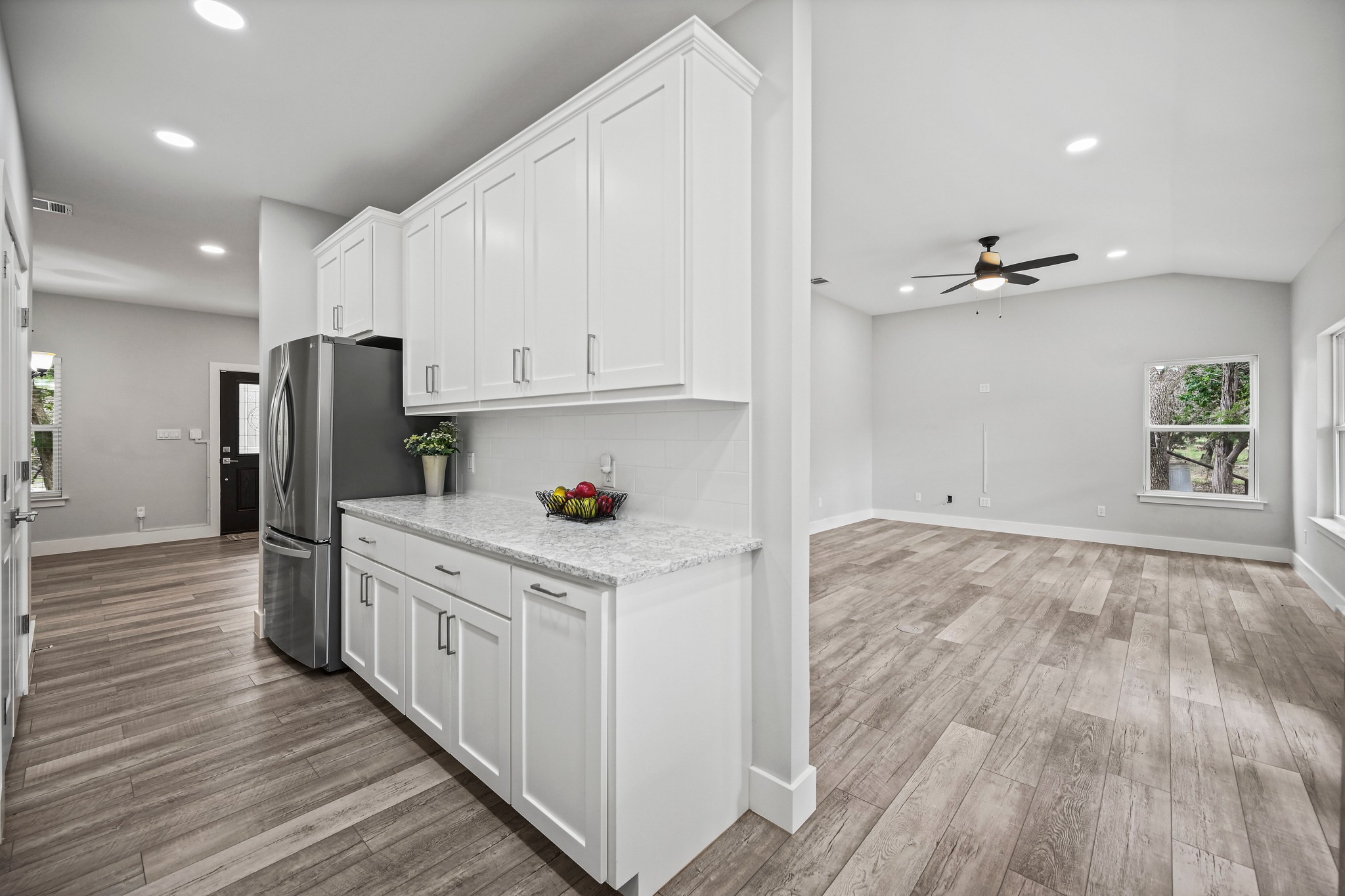 231 North Rainbow Ranch Road Wimberley, TX 78676 - Photo 16 of 40 Clean lines define this bright kitchen with modern appliances, flowing seamlessly into the inviting living space.