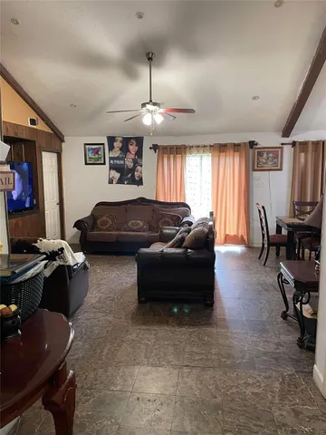 a living room with furniture a chandelier and a flat screen tv