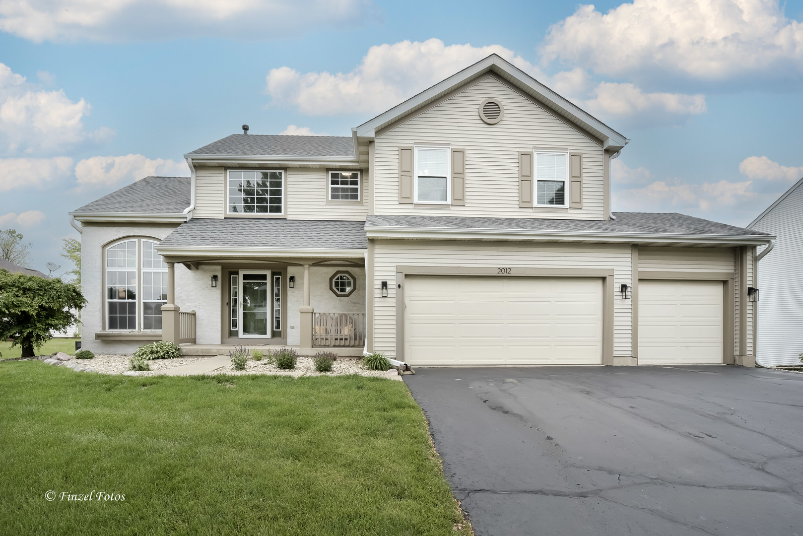 a front view of a house with a yard and garage