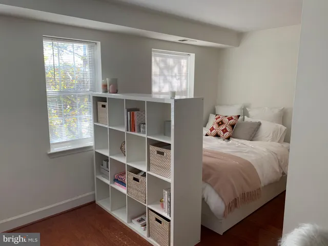 a bedroom with a bed a window and potted plant