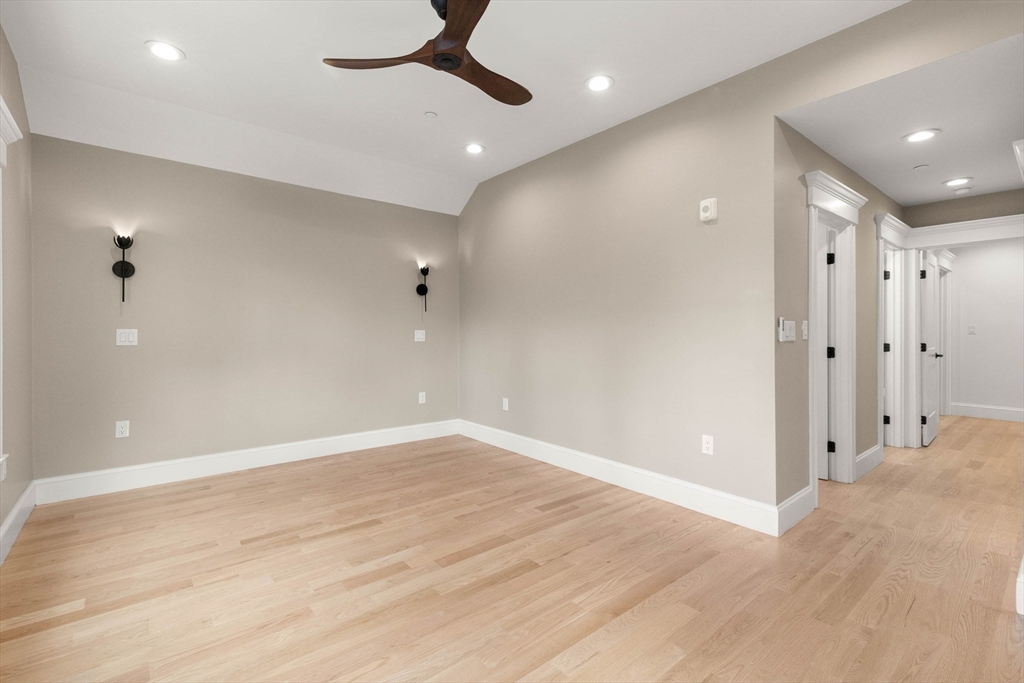 116 East Main Street, Unit 8 Gloucester, MA 01930 - Photo 13 of 31 an empty room with wooden floor and a ceiling fan