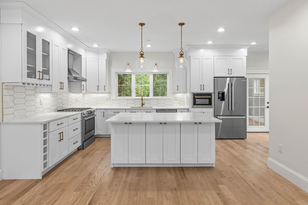 116 East Main Street, Unit 8 Gloucester, MA 01930 - Photo 5 of 31 a kitchen with stainless steel appliances white cabinets a sink a window a wooden floor and a sink
