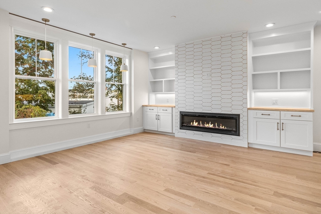 116 East Main Street, Unit 8 Gloucester, MA 01930 - Photo 6 of 31 a view of an empty room with a window and fireplace