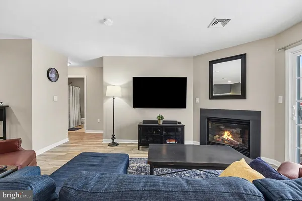 a living room with furniture a flat screen tv and a fireplace