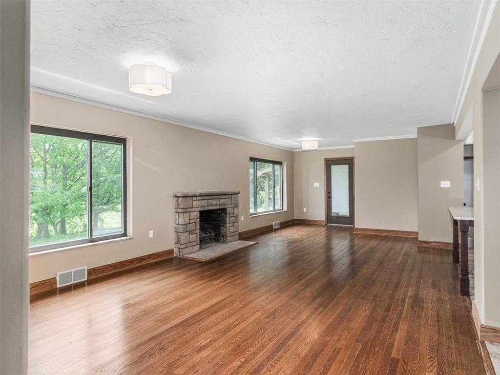 330 Center Grange Road Monaca, PA 15061 - Photo 8 of 42 an empty room with wooden floor fireplace and windows