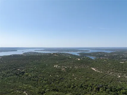 a view of a house with a yard and large tree