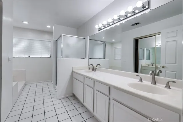 a spacious bathroom with a double vanity sink and a mirror