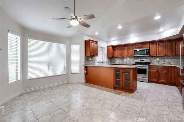 a kitchen with stainless steel appliances granite countertop a stove granite counter tops and white cabinets