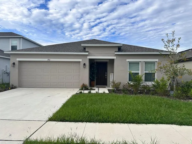 a front view of a house with a garden and yard