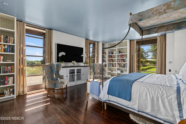 a bedroom with a bed furniture and a flat screen tv