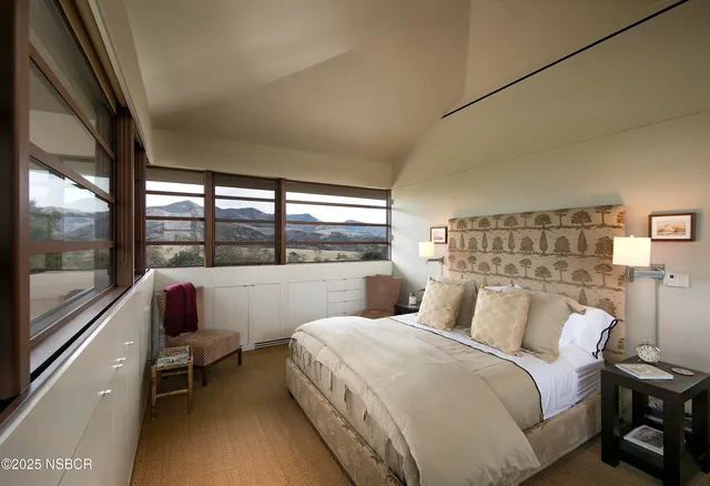 a bedroom with a bed and a large window