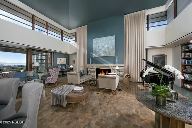 a living room with furniture floor to ceiling window and wooden floor