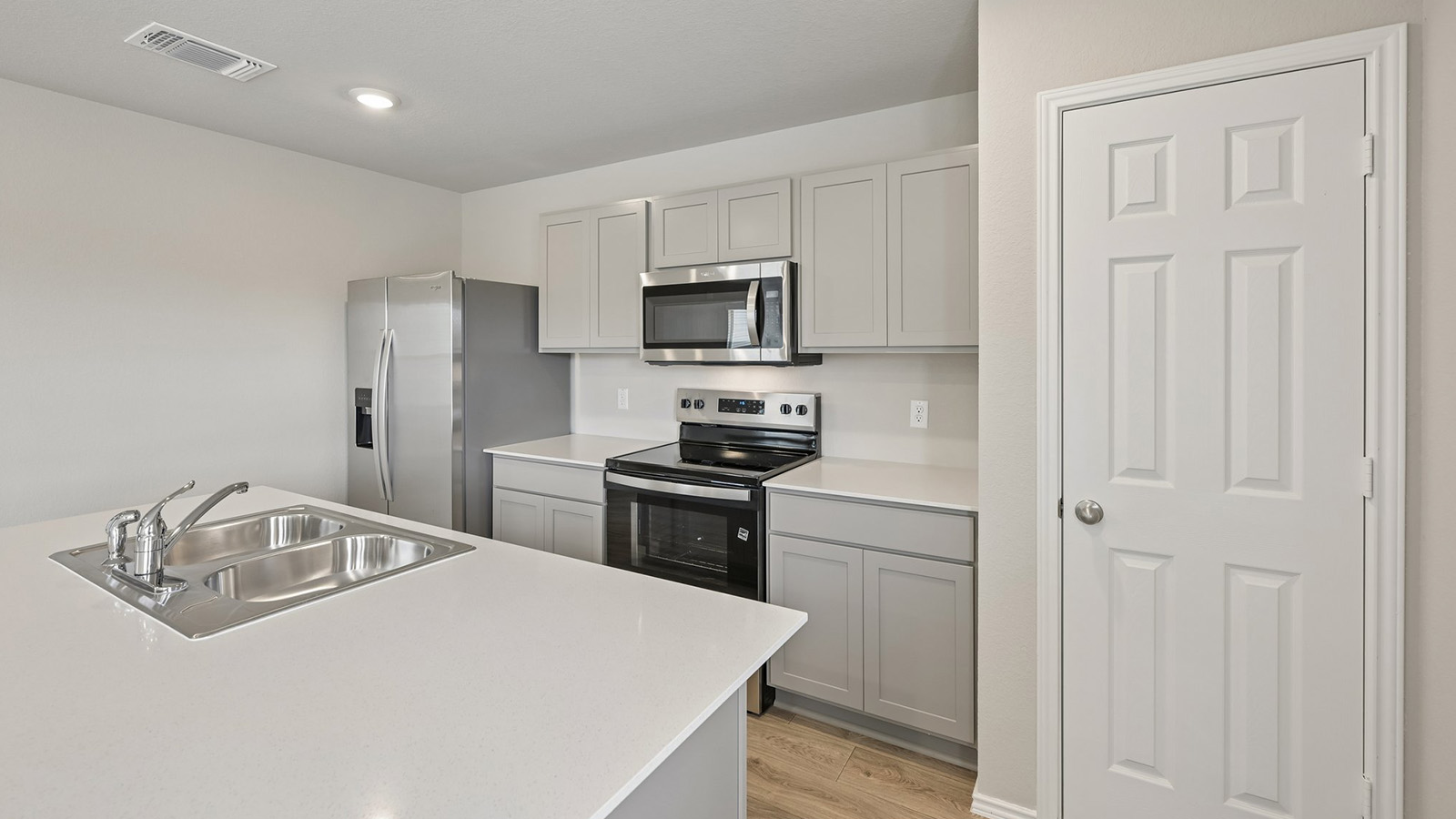 Gleaming stone countertops and modern stainless steel appliances define this streamlined, efficient culinary space.