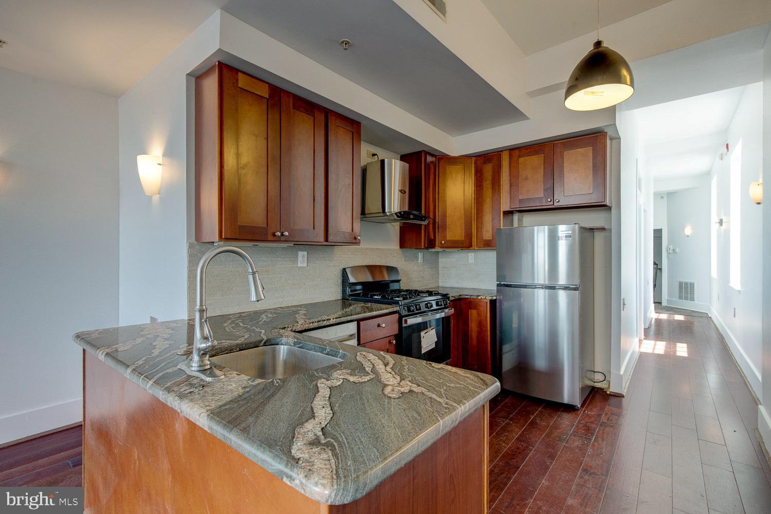 1201 South 5th Street Philadelphia, PA 19147 - Photo 42 of 57 a kitchen with stainless steel appliances granite countertop a sink refrigerator and microwave