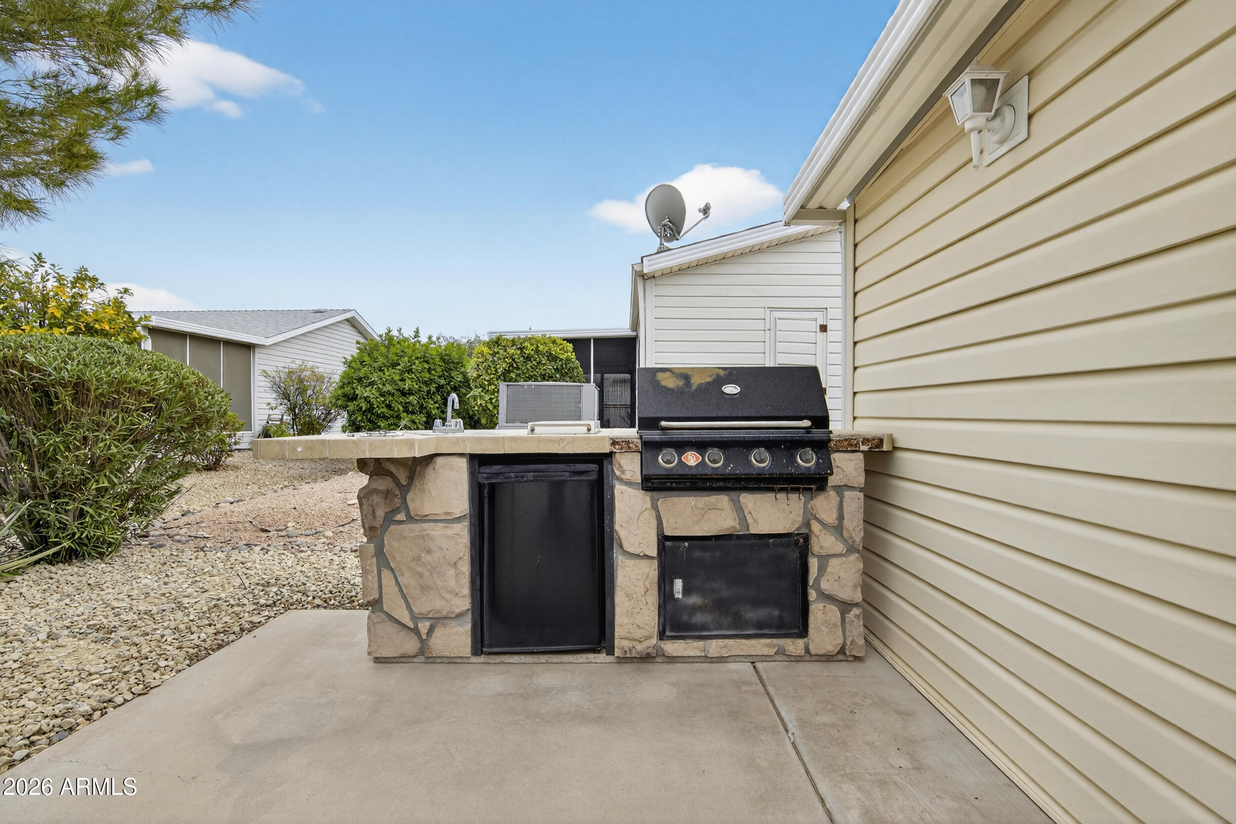 2550 South Ellsworth Road, Unit 396 Mesa, AZ 85209 - Photo 25 of 29 a view of a patio with table and chairs with wooden floor and fence