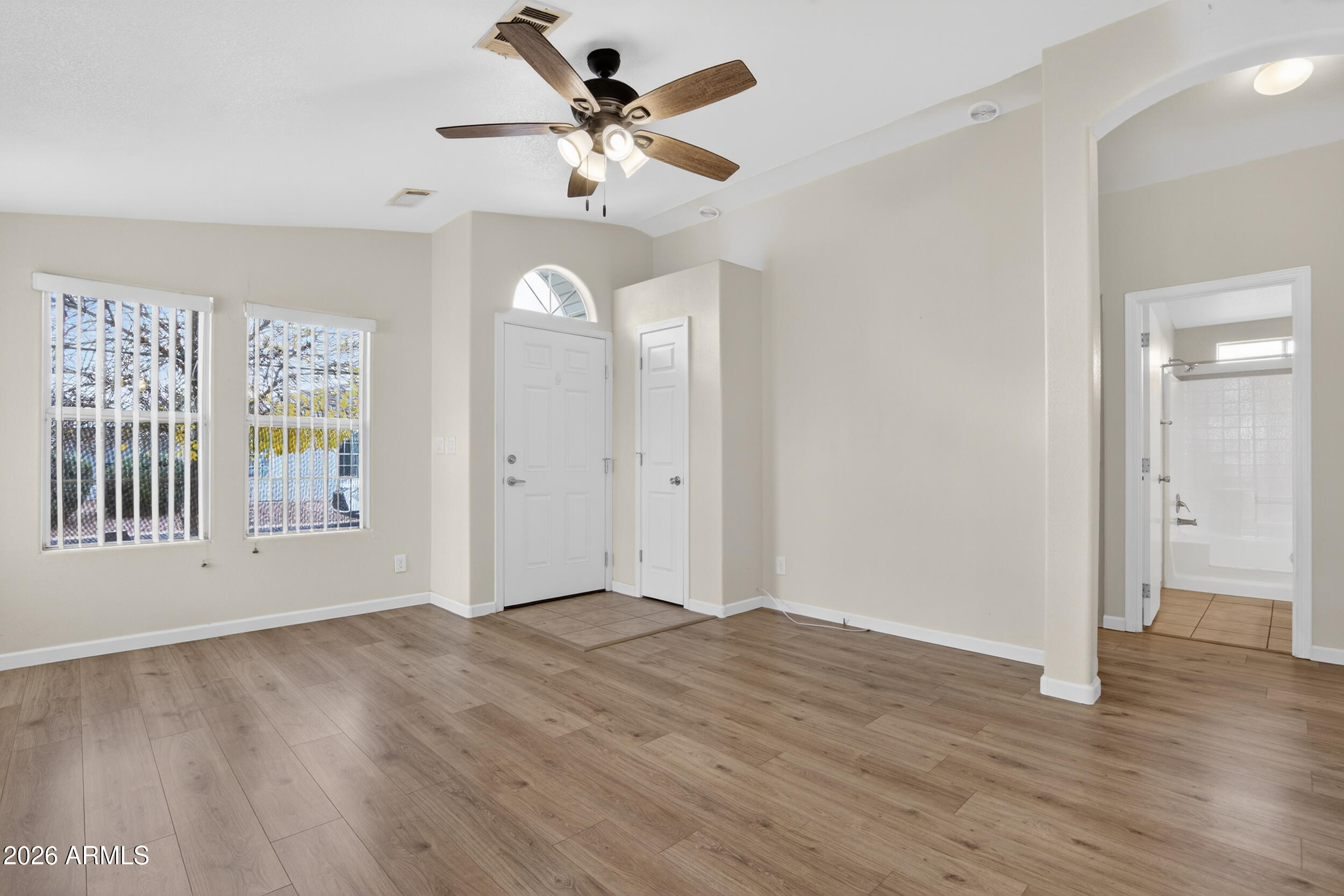 2550 South Ellsworth Road, Unit 396 Mesa, AZ 85209 - Photo 10 of 29 a view of an empty room with a window and wooden floor